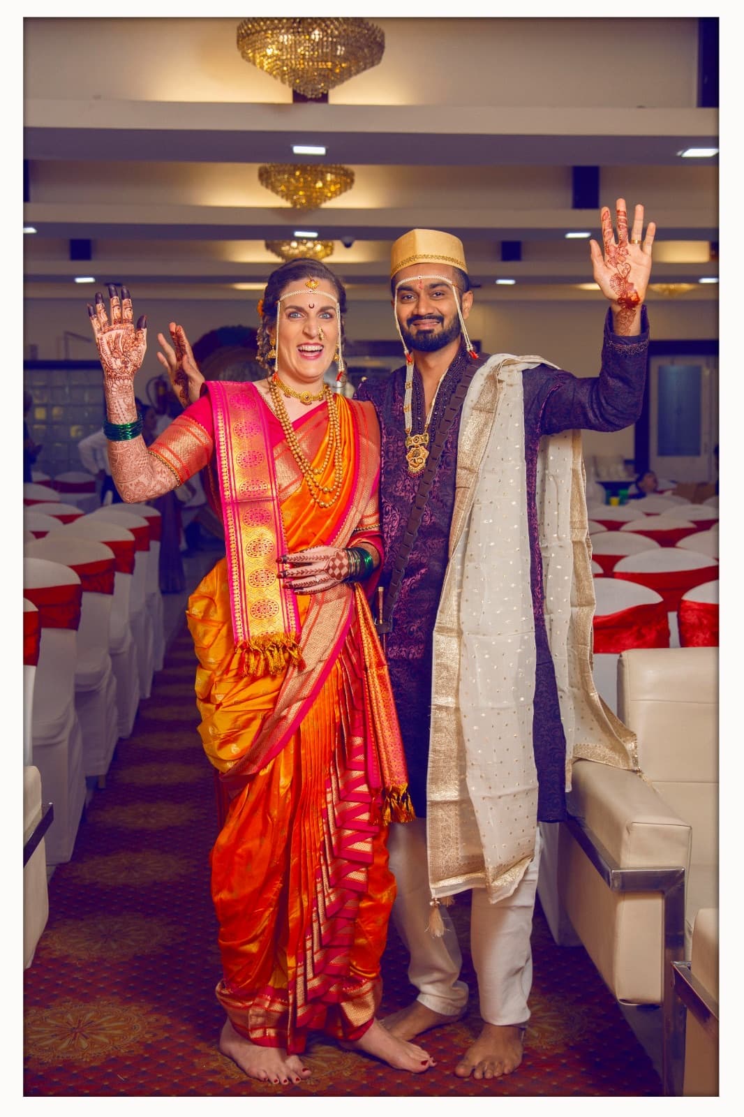 Ein Paar in Hochzeitskleidung winkt im Festsaal